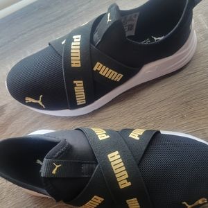 Puma Girls Tennis shoes colors are black gold and white.
